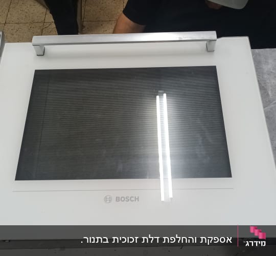 מסך בוש לבן עם ידית מתכת על שולחן